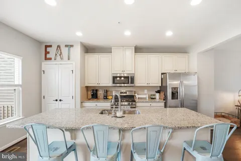 a kitchen with kitchen island granite countertop a table and chairs
