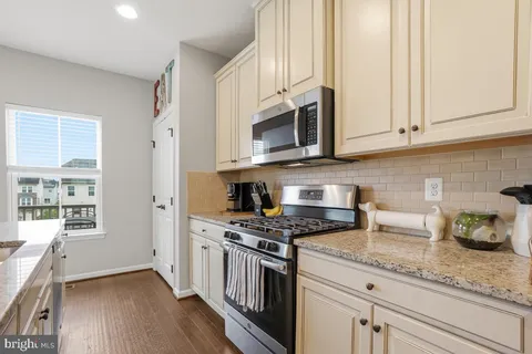 a kitchen with stainless steel appliances granite countertop a stove a sink and a white cabinets