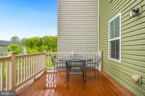 a view of a balcony with table and chairs and wooden floor