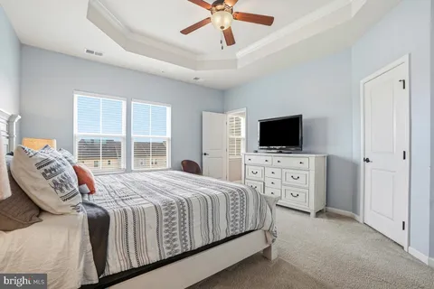 a bedroom with a bed flat screen tv and a window