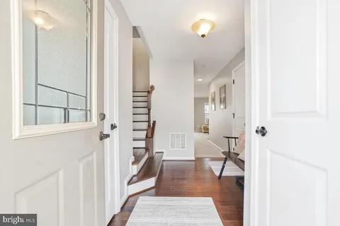 a view of a hallway with wooden floor and entryway