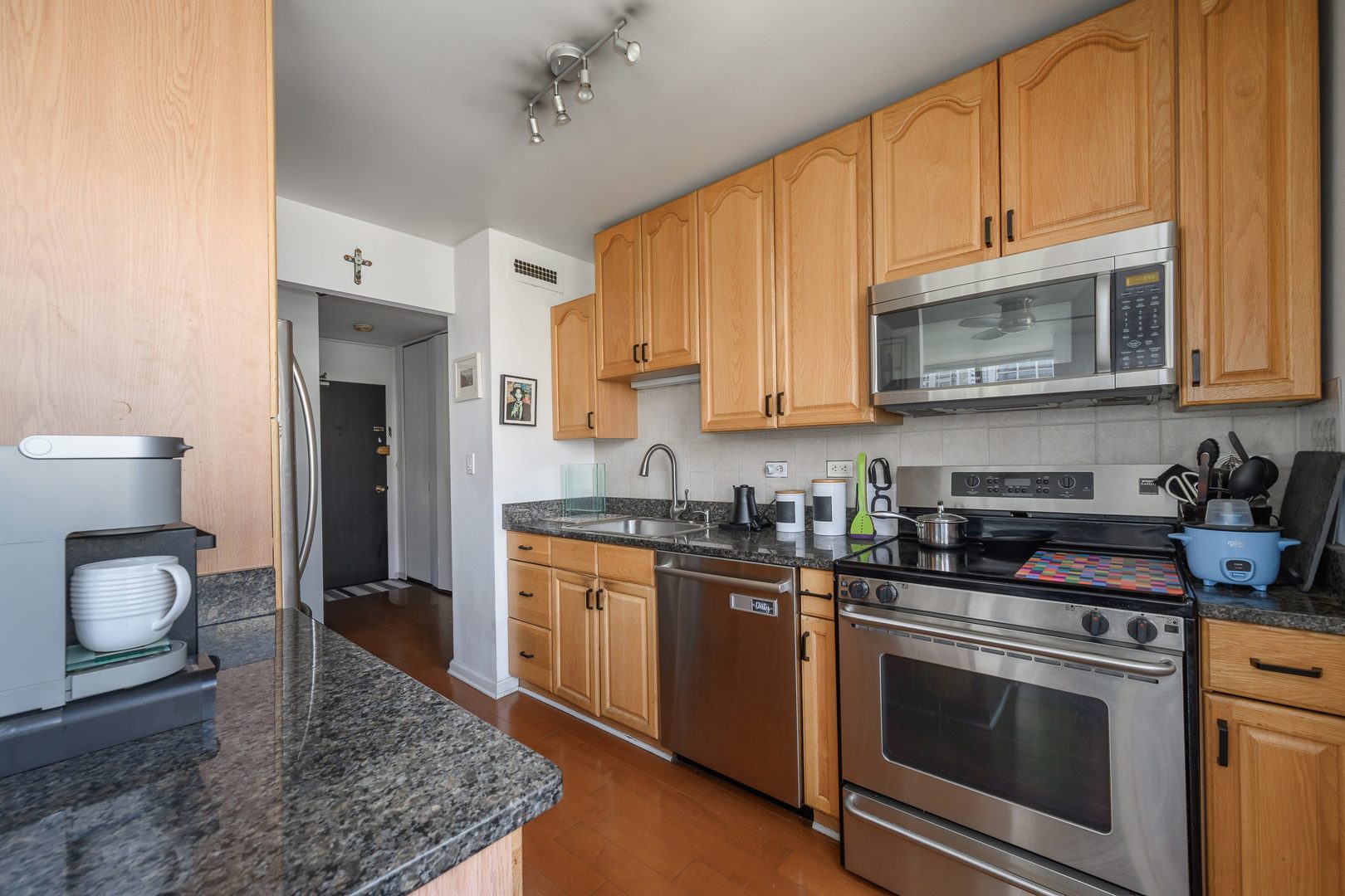 70 West Burton Place, Unit 705 Chicago, IL 60610 - Photo 9 of 17 a kitchen with stainless steel appliances granite countertop a stove a sink and a microwave