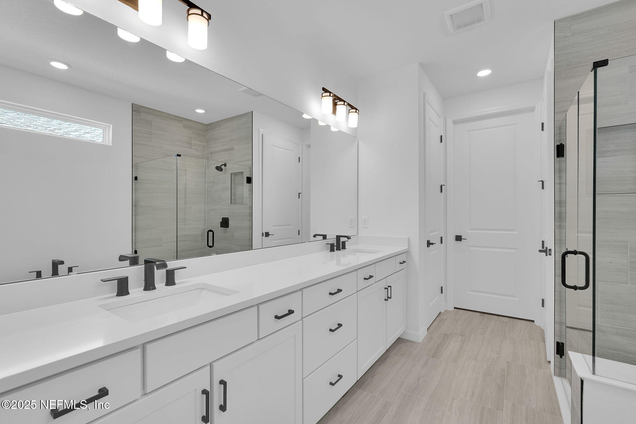 104 Headstream Drive St. Johns, FL 32259 - Photo 14 of 26 a bathroom with a double vanity sink and mirror with shower