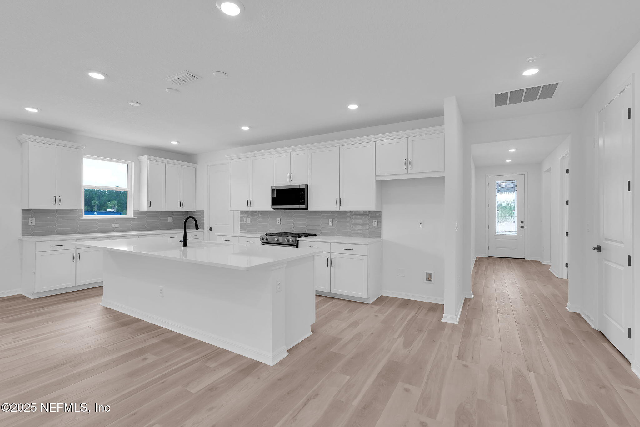 104 Headstream Drive St. Johns, FL 32259 - Photo 4 of 26 a kitchen with white cabinets and stainless steel appliances