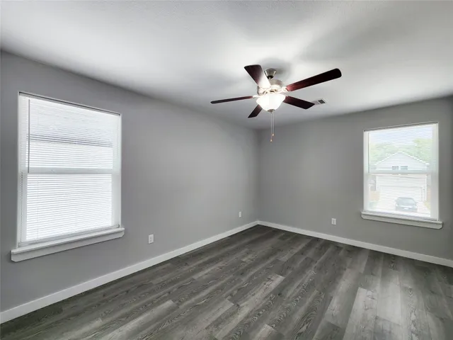 a kitchen with granite countertop a stove top oven a sink dishwasher a dining table and chairs with wooden floor