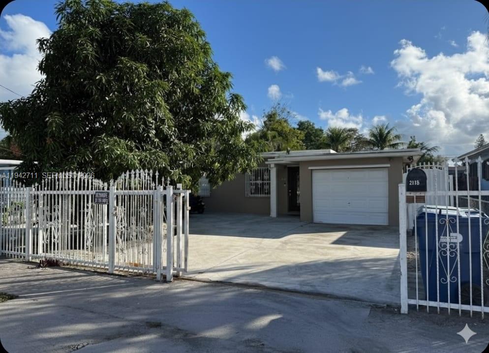a view of a house with a small yard and wooden fence