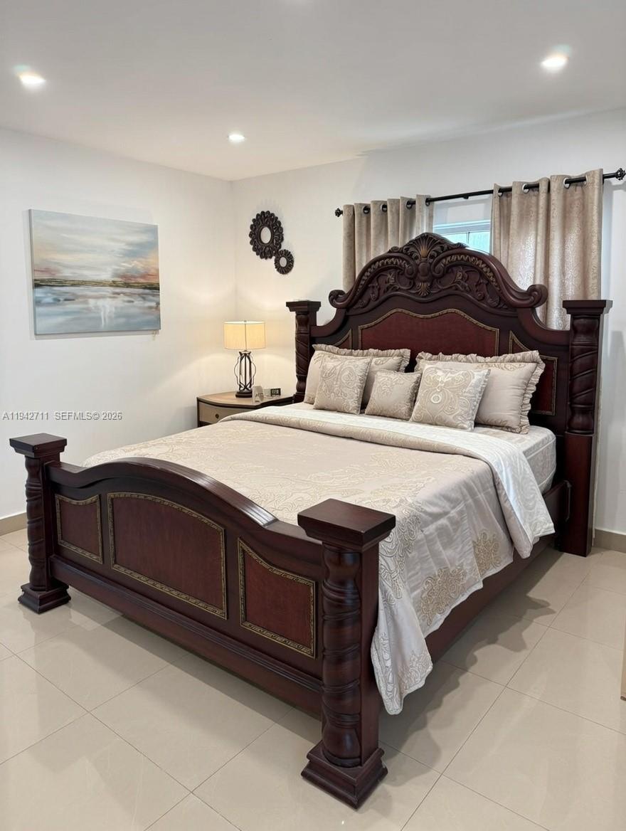 2118 Northwest 86th Street Miami, FL 33147 - Photo 6 of 10 a bedroom with a bed and wooden floor