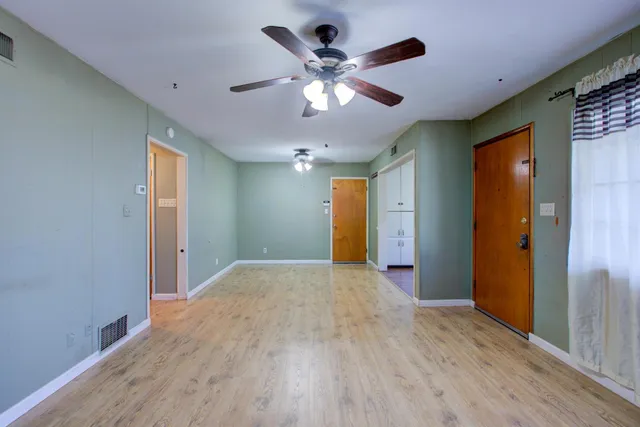 a view of empty room with wooden floor