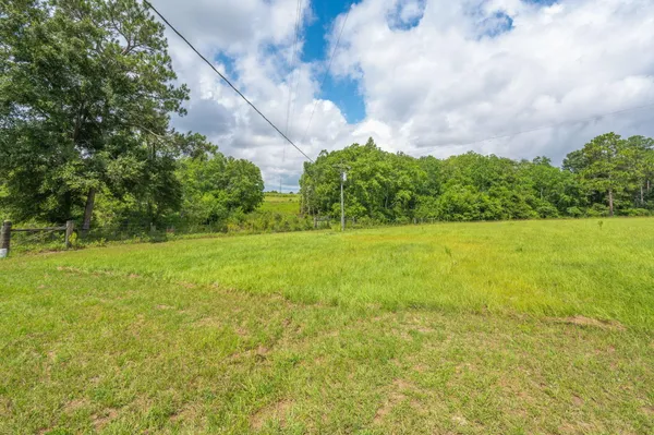 a view of a green field with wooden fence