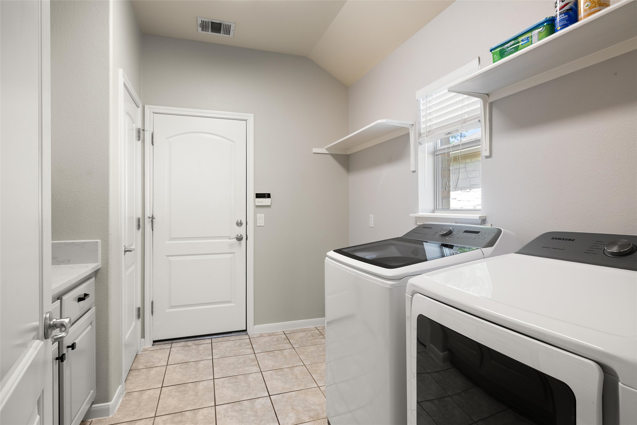 100 Stratton Court Austin, TX 78737 - Photo 27 of 38 The laundry room has room for folding and storage, plus the washer/dryer AND extra fridge (located behind door) convey!