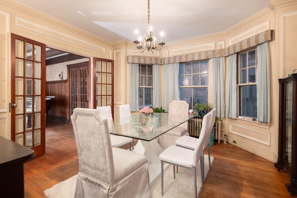 67 Crowninshield Road Brookline, MA 02446 - Photo 8 of 23 a dining room with furniture a chandelier and wooden floor