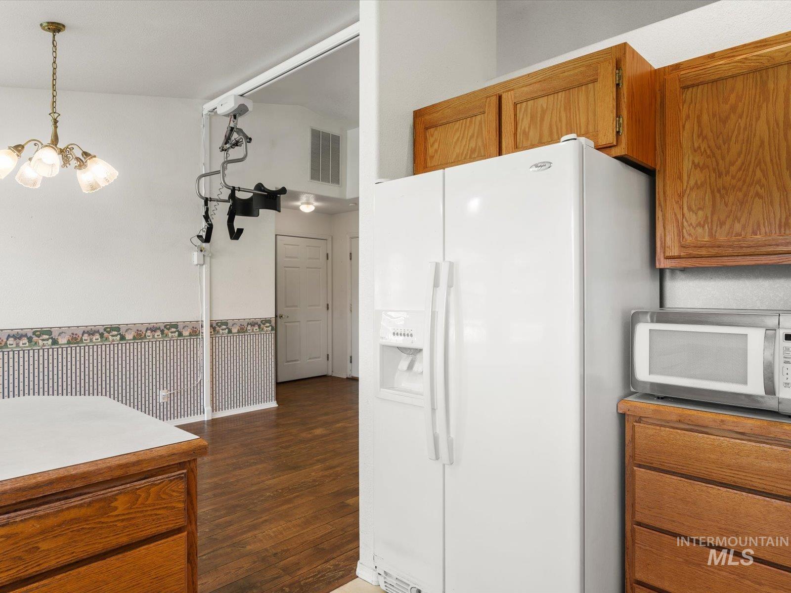3540 Wills Road Emmett, ID 83617 - Photo 14 of 36 Kitchen area featuring wood-finish cabinetry, a white side-by-side refrigerator, and a built-in microwave nook
