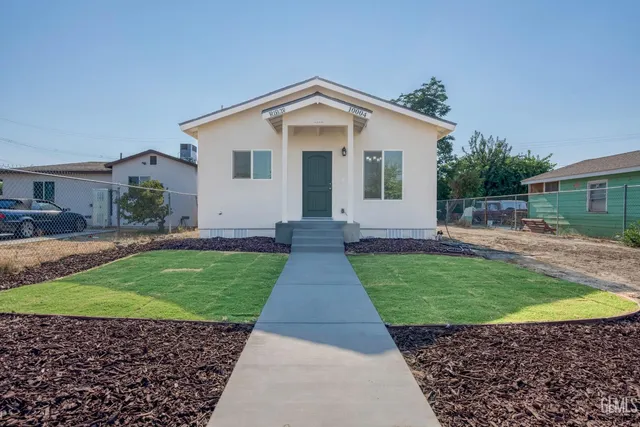 a view of a house with a small yard and potted plants