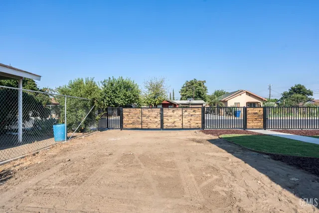 a view of white house with a yard and potted plants