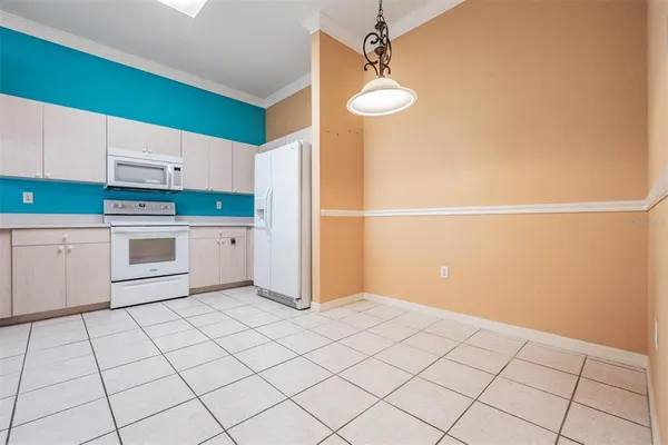 a view of an empty room with a window and a kitchen