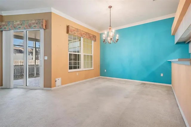 a view of a livingroom with a chandelier fan and windows