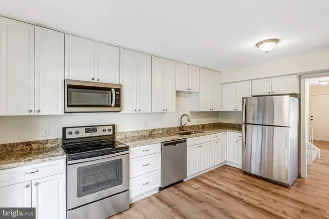 a kitchen with a refrigerator sink and cabinets
