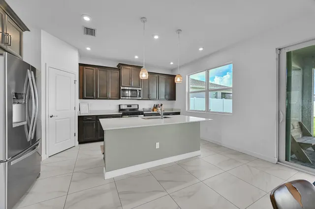 a kitchen with kitchen island a sink stove and refrigerator