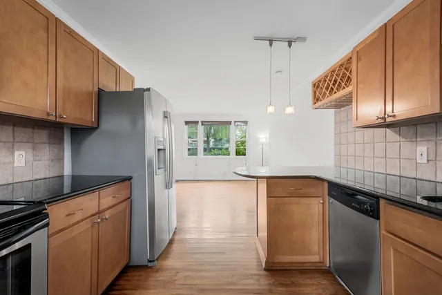 a kitchen with stainless steel appliances granite countertop a sink a stove and a refrigerator