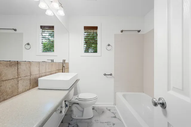 a bathroom with a toilet sink and mirror