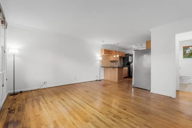 a view of empty room with wooden floor