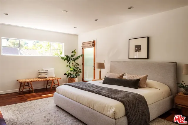 a bedroom with a bed and wooden floor