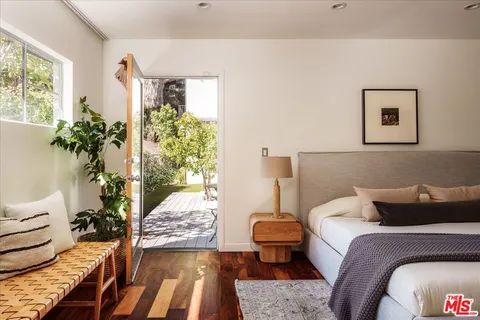 a bedroom with a bed and wooden floor