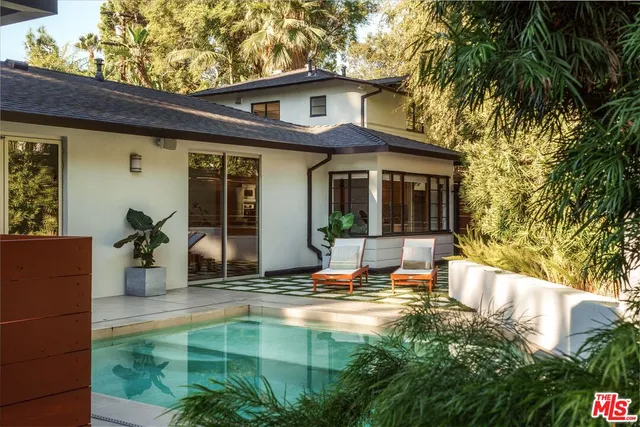 a backyard of a house with fire pit and outdoor seating