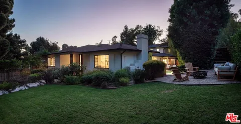 a view of a chairs and table in backyard of the house