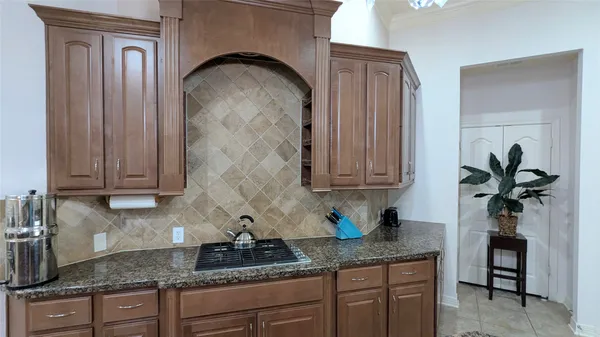 a kitchen with granite countertop a sink a stove and cabinets