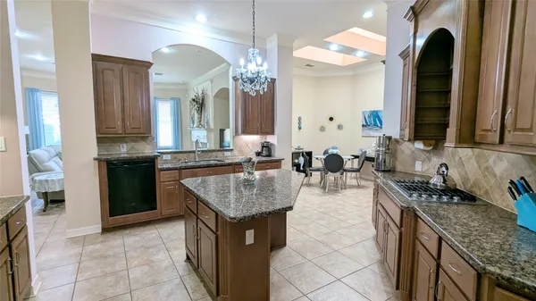 a kitchen with granite countertop a sink stove and cabinets