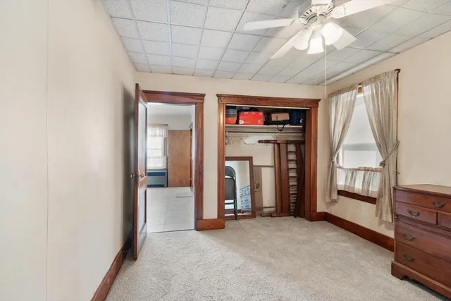 en empty room with windows and ceiling fan