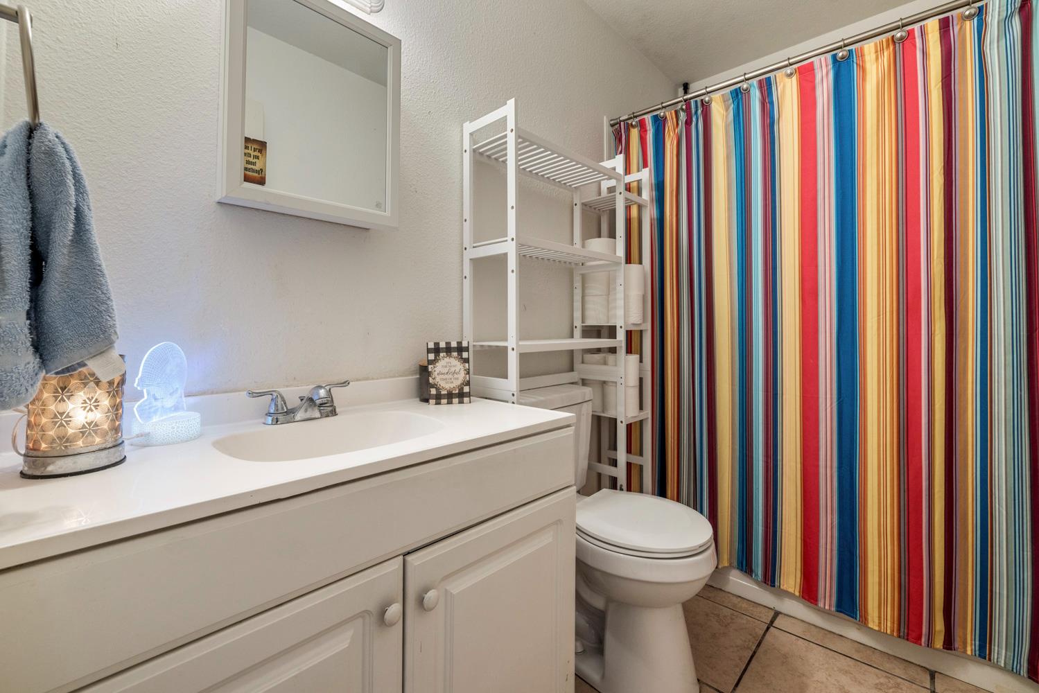 2644 San Ignacio Avenue Modesto, CA 95354 - Photo 14 of 32 a bathroom with a sink a toilet and a mirror