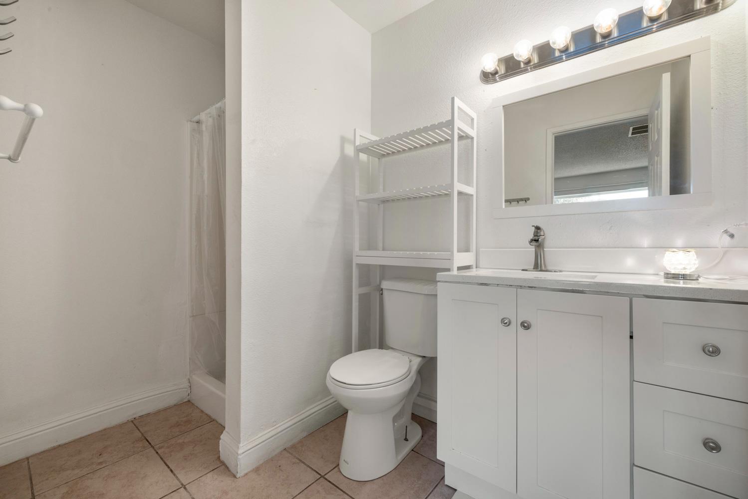 2644 San Ignacio Avenue Modesto, CA 95354 - Photo 22 of 32 a bathroom with a granite countertop sink toilet a mirror and vanity