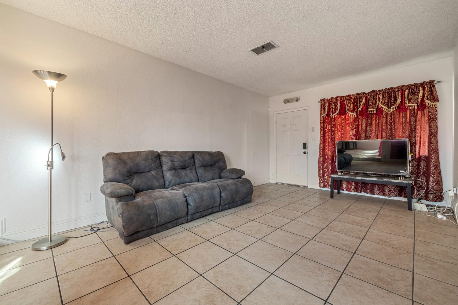 2644 San Ignacio Avenue Modesto, CA 95354 - Photo 6 of 32 a living room with furniture and a flat screen tv