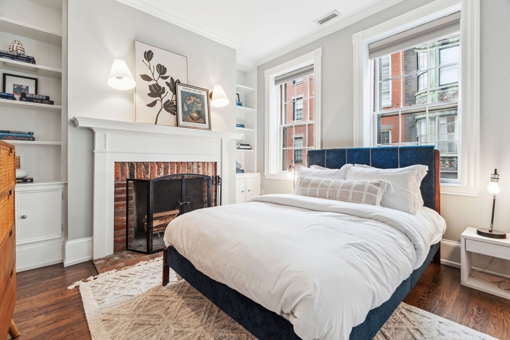 61 Revere Street, Unit 3 Boston, MA 02114 - Photo 11 of 15 a bedroom with a bed and a fireplace