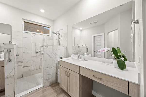 a bathroom with a shower sink and mirror