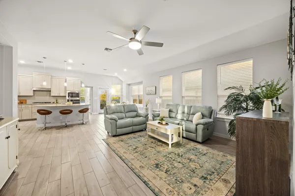 a living room with furniture and view of kitchen