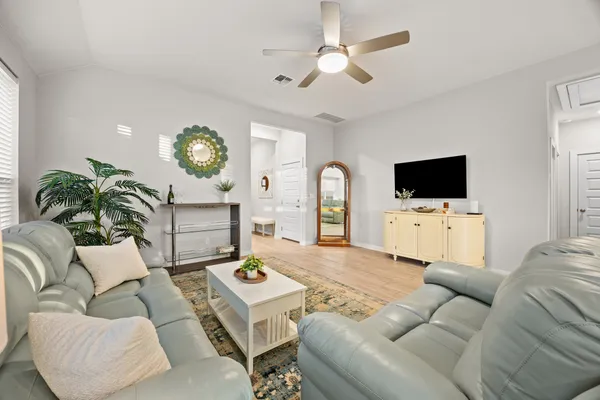 a living room with furniture a flat screen tv and a window