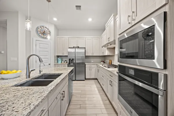a large kitchen with stainless steel appliances granite countertop a sink and stove