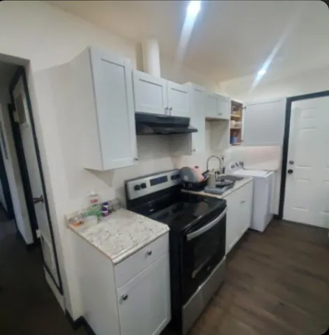 a kitchen with a stove sink and cabinets