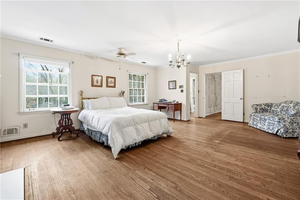 956 West Wesley Road Northwest Atlanta, GA 30327 - Photo 27 of 49 a spacious bedroom with a bed a dresser and windows