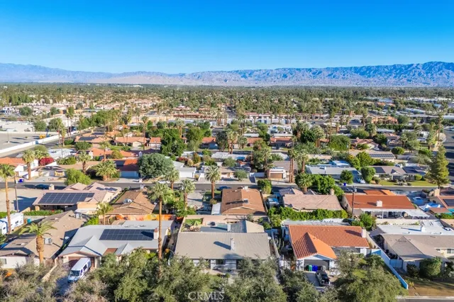 an aerial view of a city with lots of residential buildings and mountain view in back