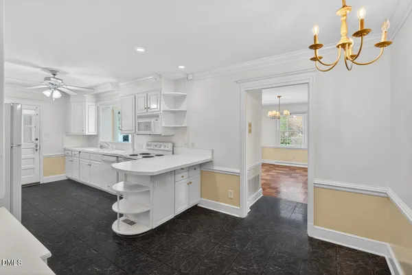 a large white kitchen with a sink stainless steel appliances and cabinets