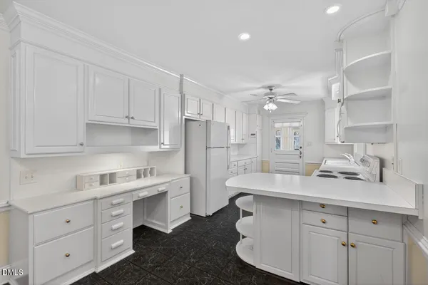 a kitchen with a sink dishwasher a stove and white cabinets with wooden floor