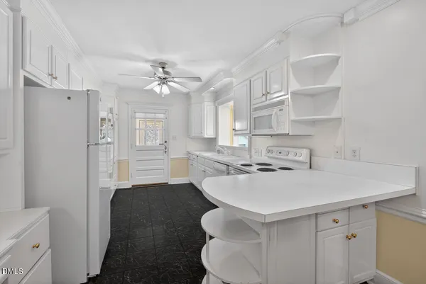 a kitchen that has a sink a stove and a refrigerator