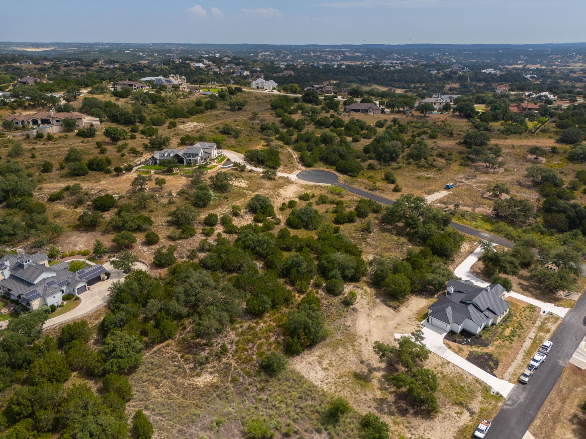 115 Upper River Place Spring Branch, TX 78070 - Photo 4 of 19 An aerial perspective reveals rolling terrain dotted with native trees and distant neighborhood views.