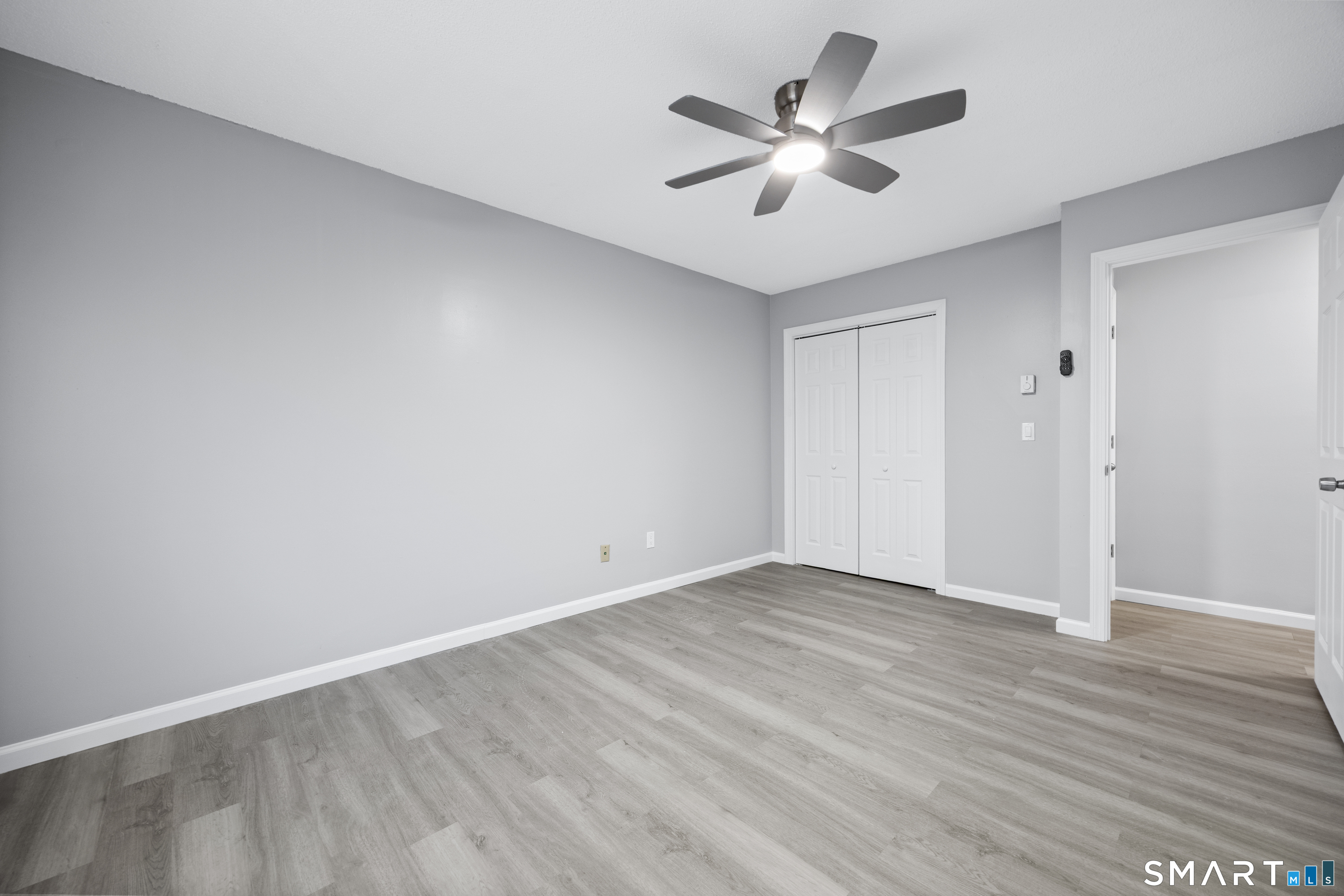 36 Sharon Road, Unit 11 Waterbury, CT 06705 - Photo 13 of 13 an empty room with wooden floor and ceiling fan
