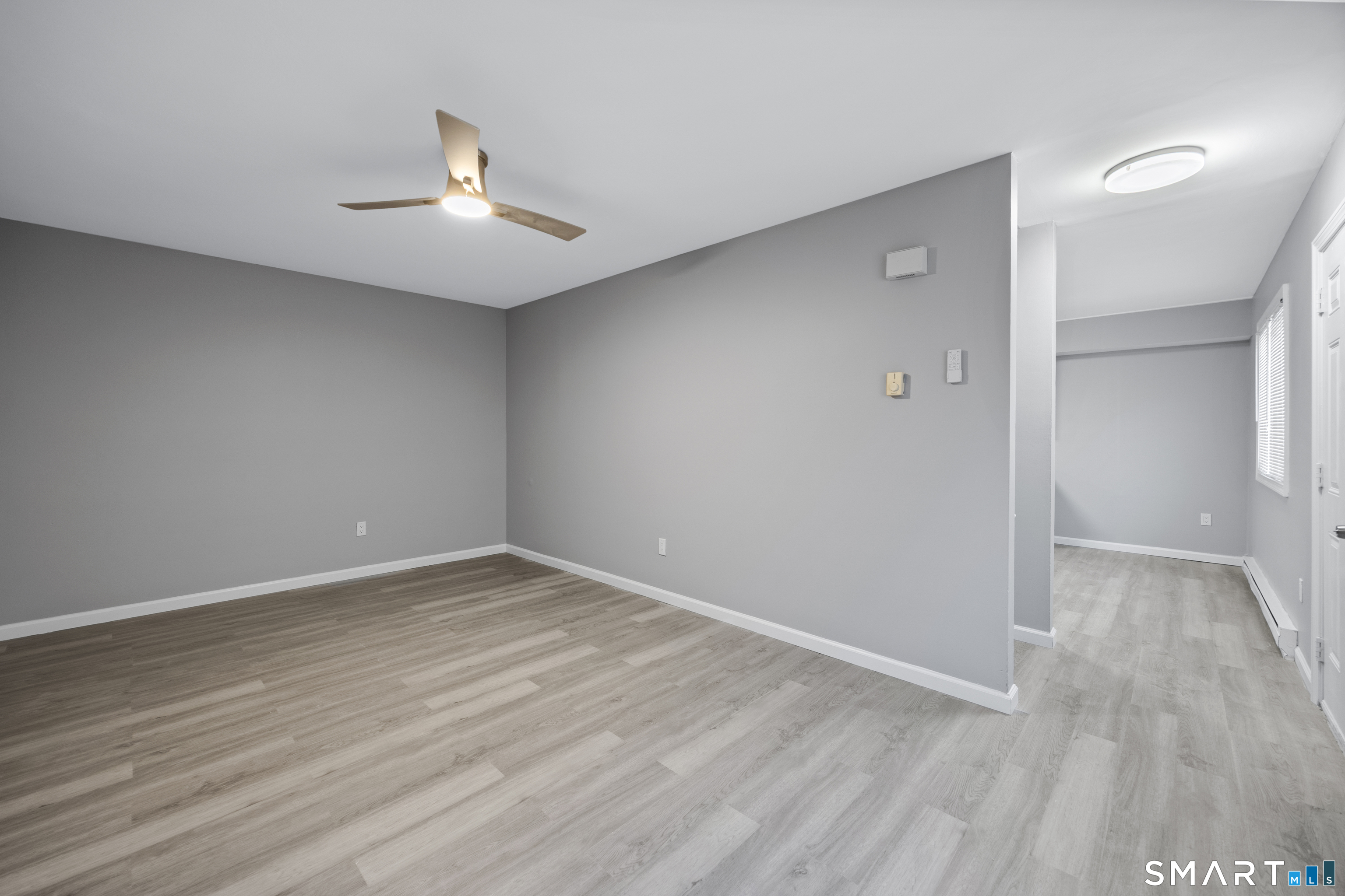 36 Sharon Road, Unit 11 Waterbury, CT 06705 - Photo 9 of 13 an empty room with wooden floor and windows