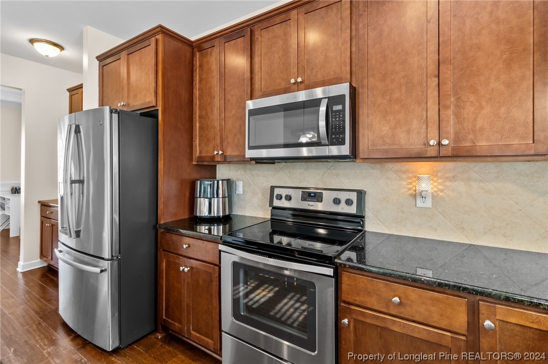 6817 Hunters Den Road Hope Mills, NC 28348 - Photo 11 of 49 a kitchen with stainless steel appliances granite countertop a refrigerator stove and microwave